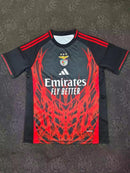 Camisola concept vermelha e preta com símbolo AS CORES 2025/26